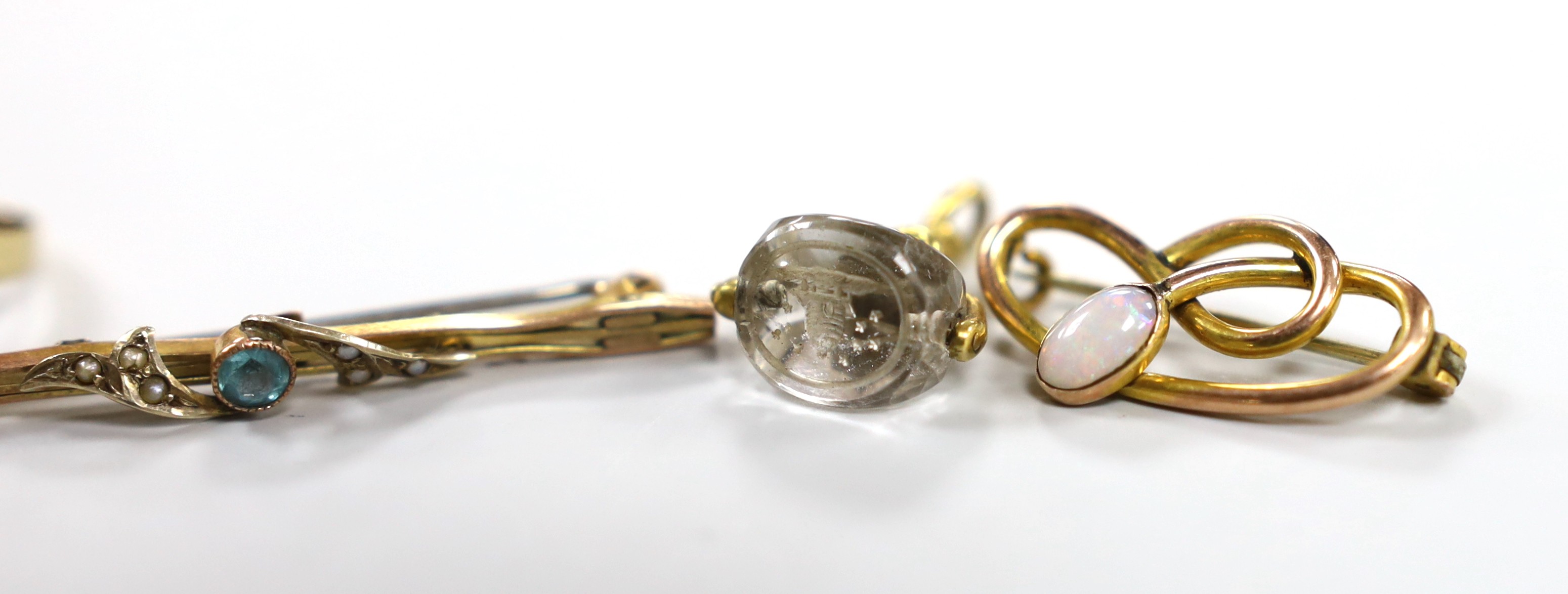 A Victorian yellow metal mounted rock crystal fob seal, 21mm, two yellow metal bar brooches including 9ct gold, an Edwardian Art Nouveau 9ct gold and white opal set scroll brooch by Charles Horner and four other items in